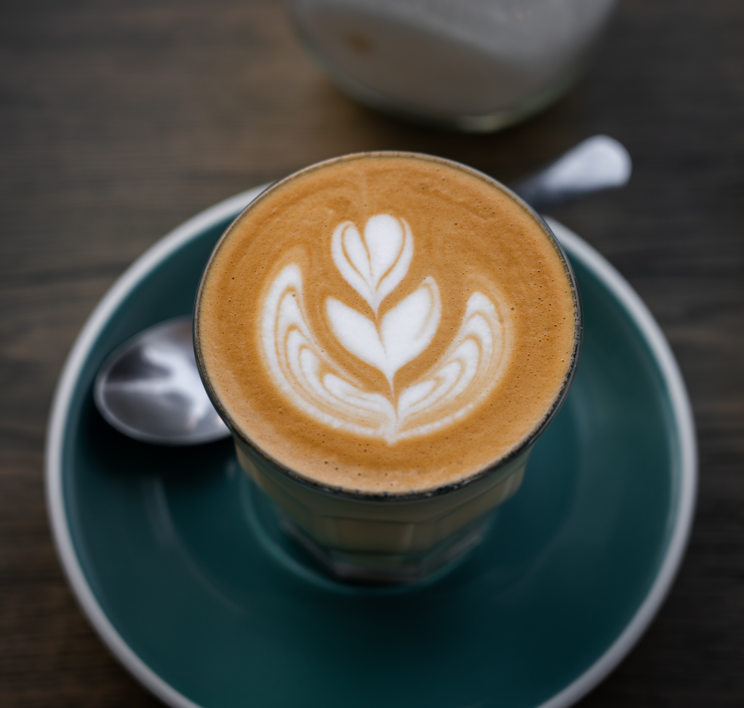 A brown colored latte with white decorative foam