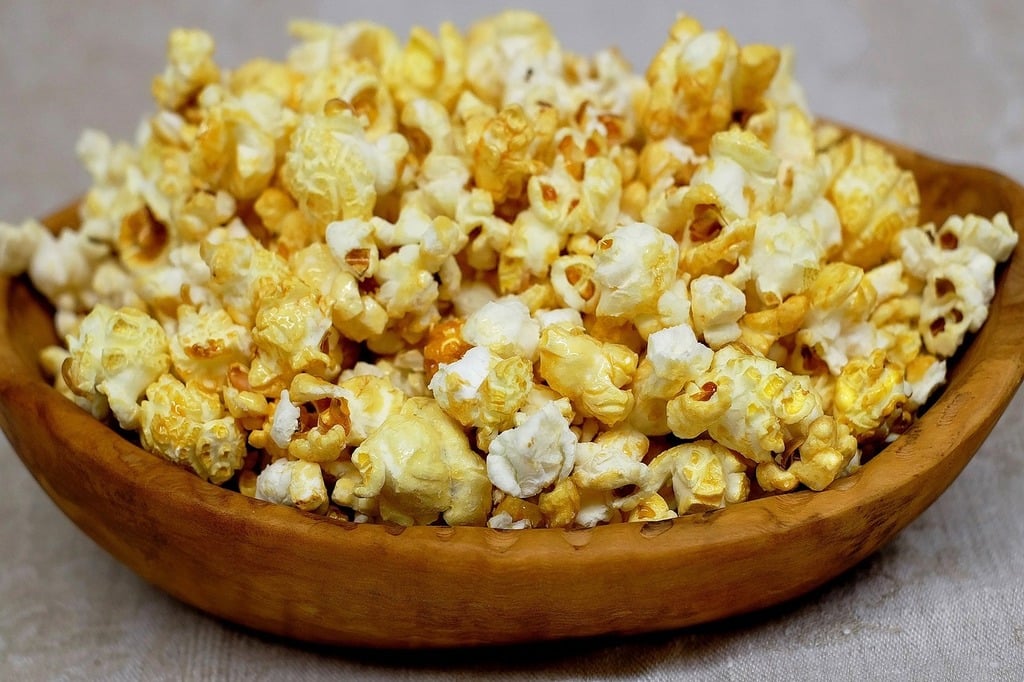 Buttery yellow popcorn in a wooden bowl
